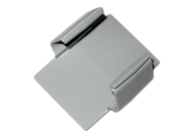 Grå plastrektangulär klämma med två upphöjda kanter, placerad på en vit bakgrund.