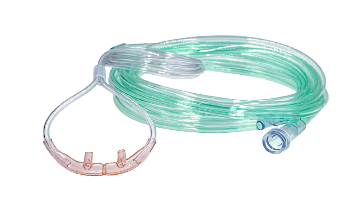 En näsgrimma för syrgastillförsel med lång grön slang, liggande på vit bakgrund.