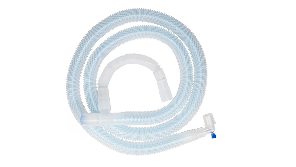 Medicinskt andningsslangsystem i plast med böjda och raka sektioner på vit bakgrund.
