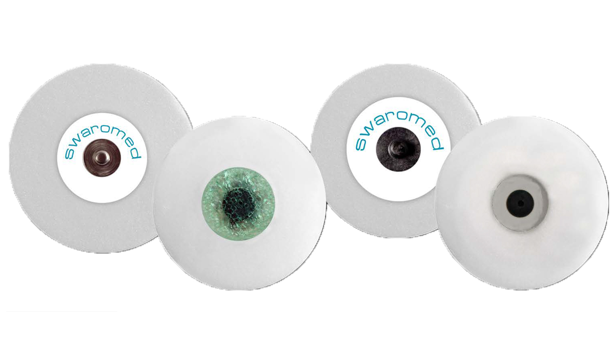 Fyra runda självhäftande EKG-elektroder med olika mittenfärger och märkningen "swaromed" syns.